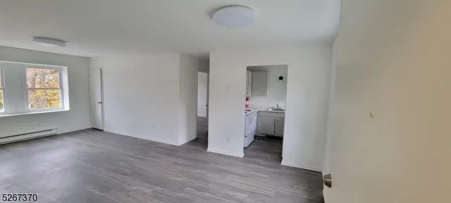 a view of a room with wooden floor and a bathroom