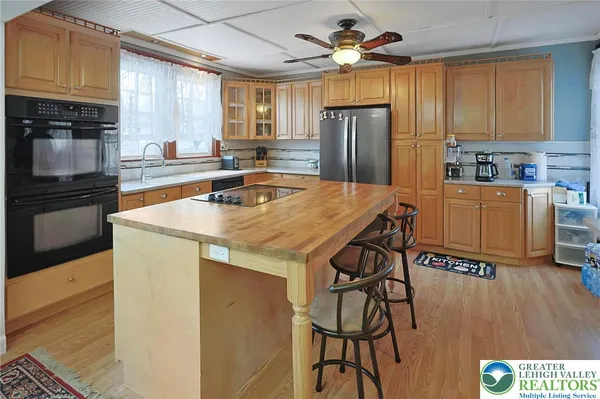 a kitchen with stainless steel appliances granite countertop a refrigerator a stove top oven a sink dishwasher and wooden cabinets