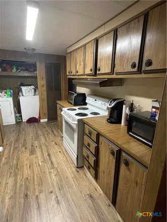 a kitchen with a stove and a wooden floor