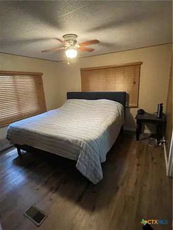 a bedroom with a bed and wooden floor