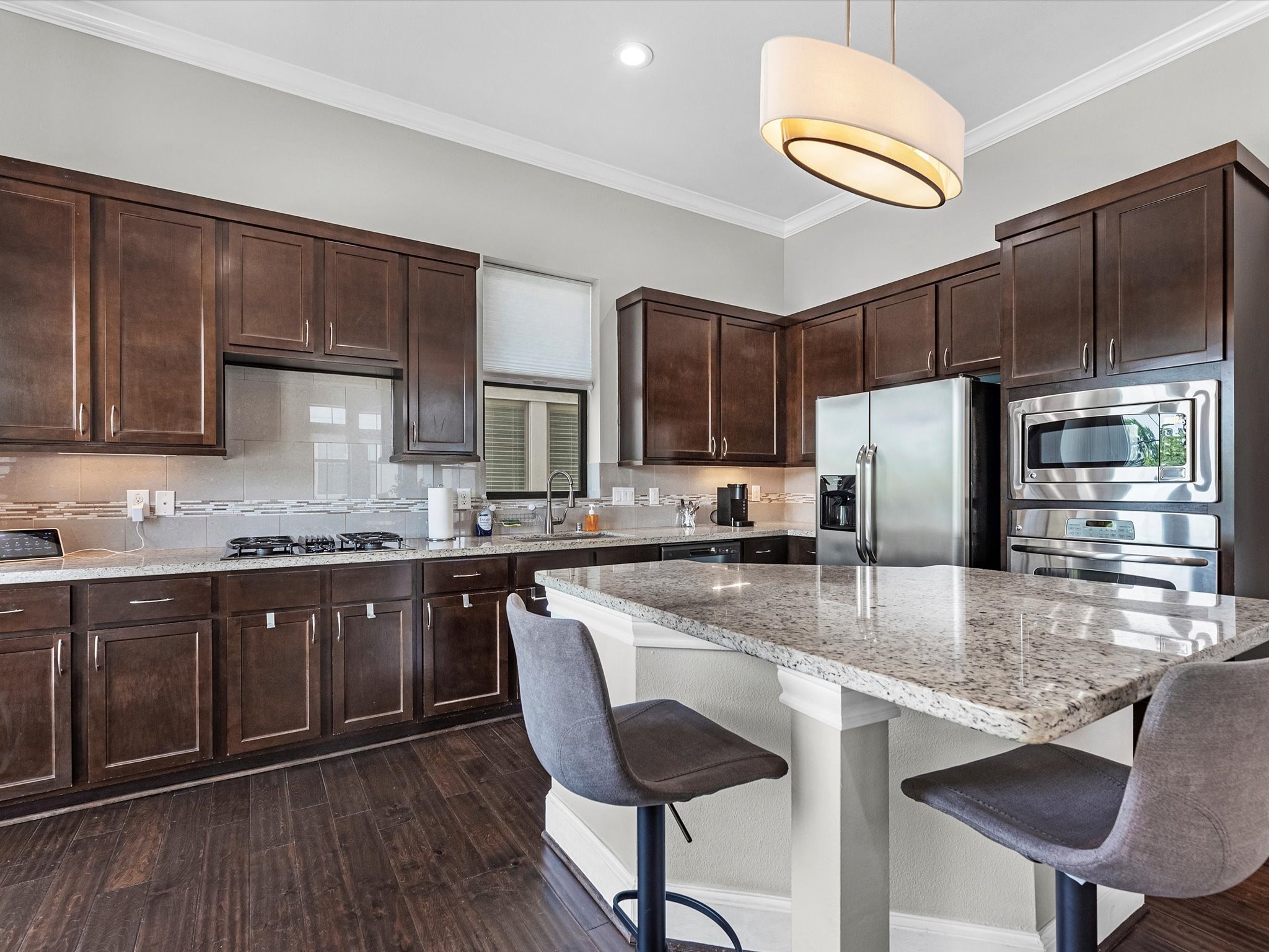 3610 Chenevert Street Houston, TX 77004 - Photo 12 of 32 This stunning kitchen has 42" cabinets, granite countertops, a stylish tile backsplash, and an island perfect for barstools.