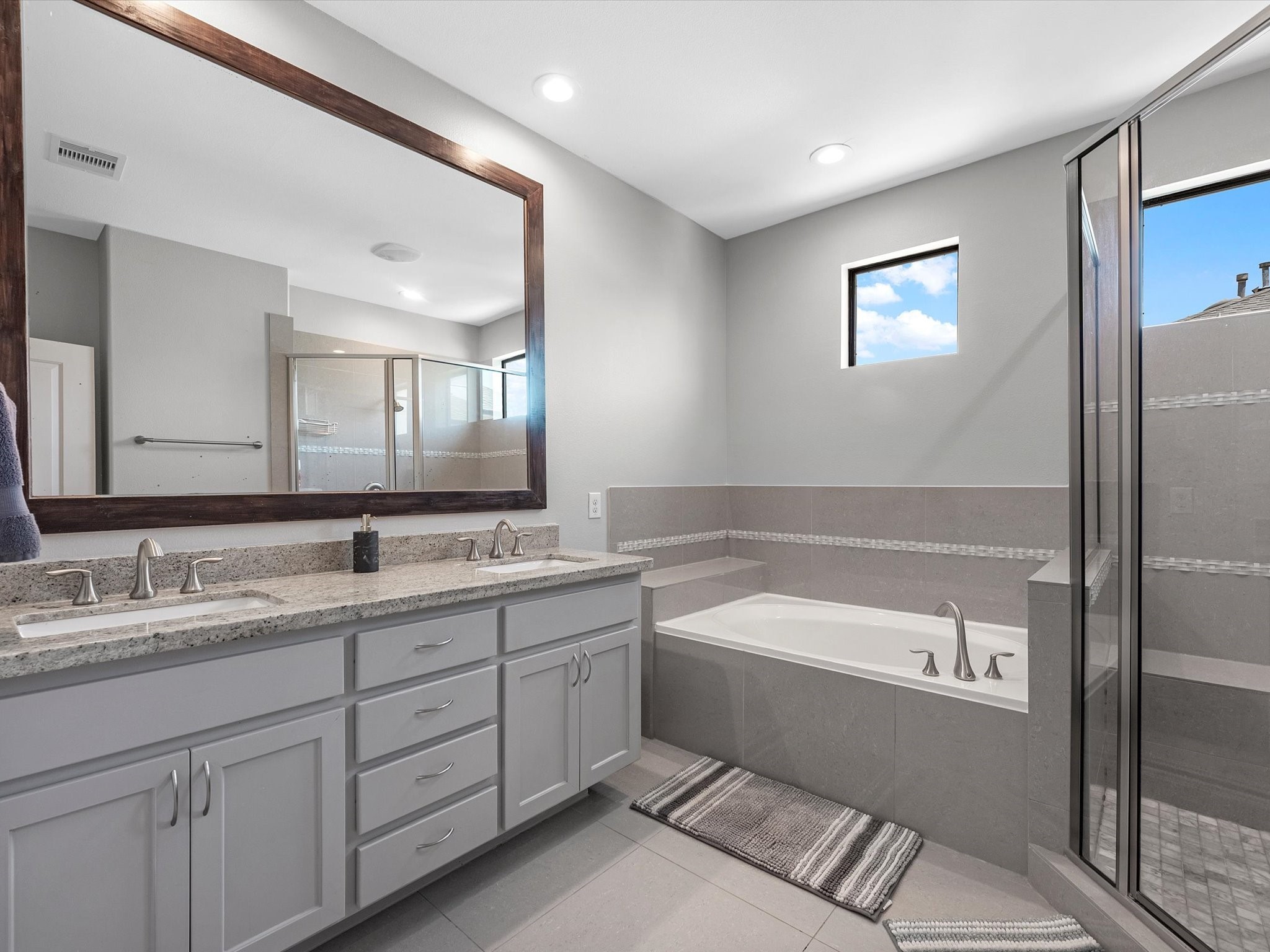 3610 Chenevert Street Houston, TX 77004 - Photo 20 of 32 Sleek double vanity with a framed mirror and excellent lighting.