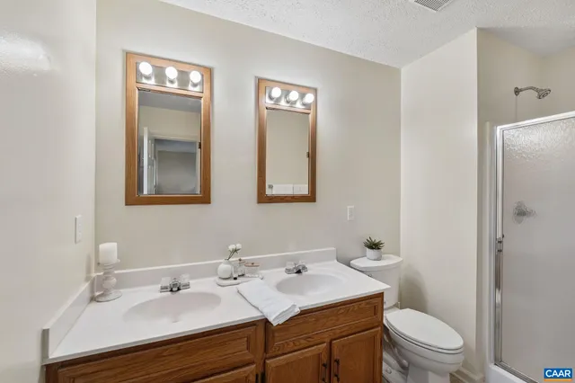a bathroom with a sink toilet a mirror and shower