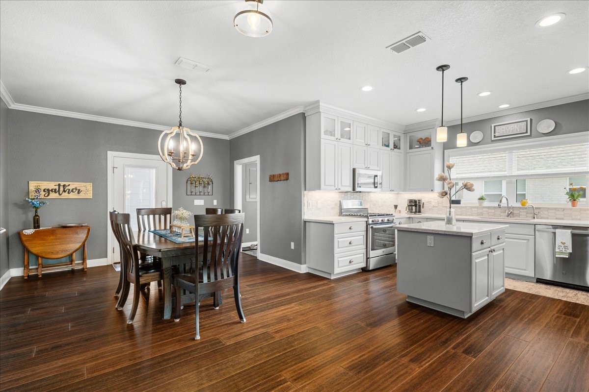 1207 Pecan Street Brenham, TX 77833 - Photo 9 of 29 a kitchen with stainless steel appliances a dining table chairs stove and cabinets
