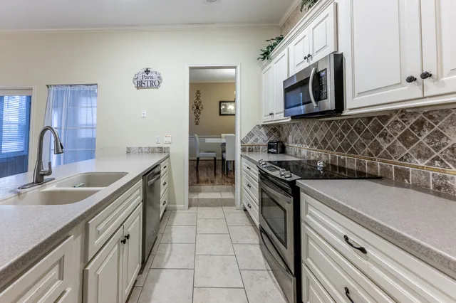 a kitchen with granite countertop a stove top oven microwave and cabinets
