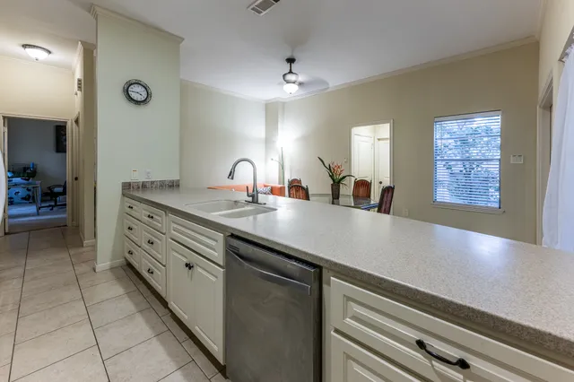a view of a hallway with a livingroom and a bathroom with sink