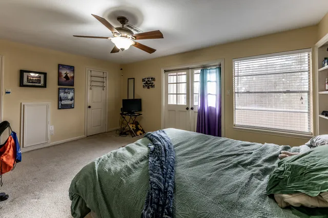 a bedroom with a bed window and a desk