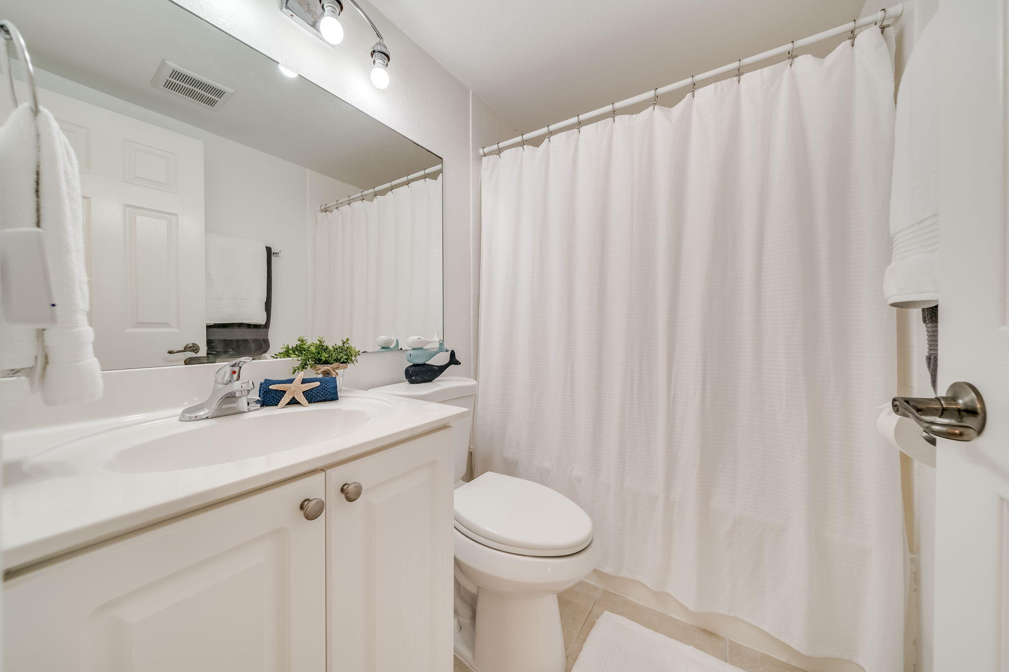 8116 Severn Drive, Unit C Boca Raton, FL 33433 - Photo 22 of 52 a bathroom with a sink a toilet and a mirror