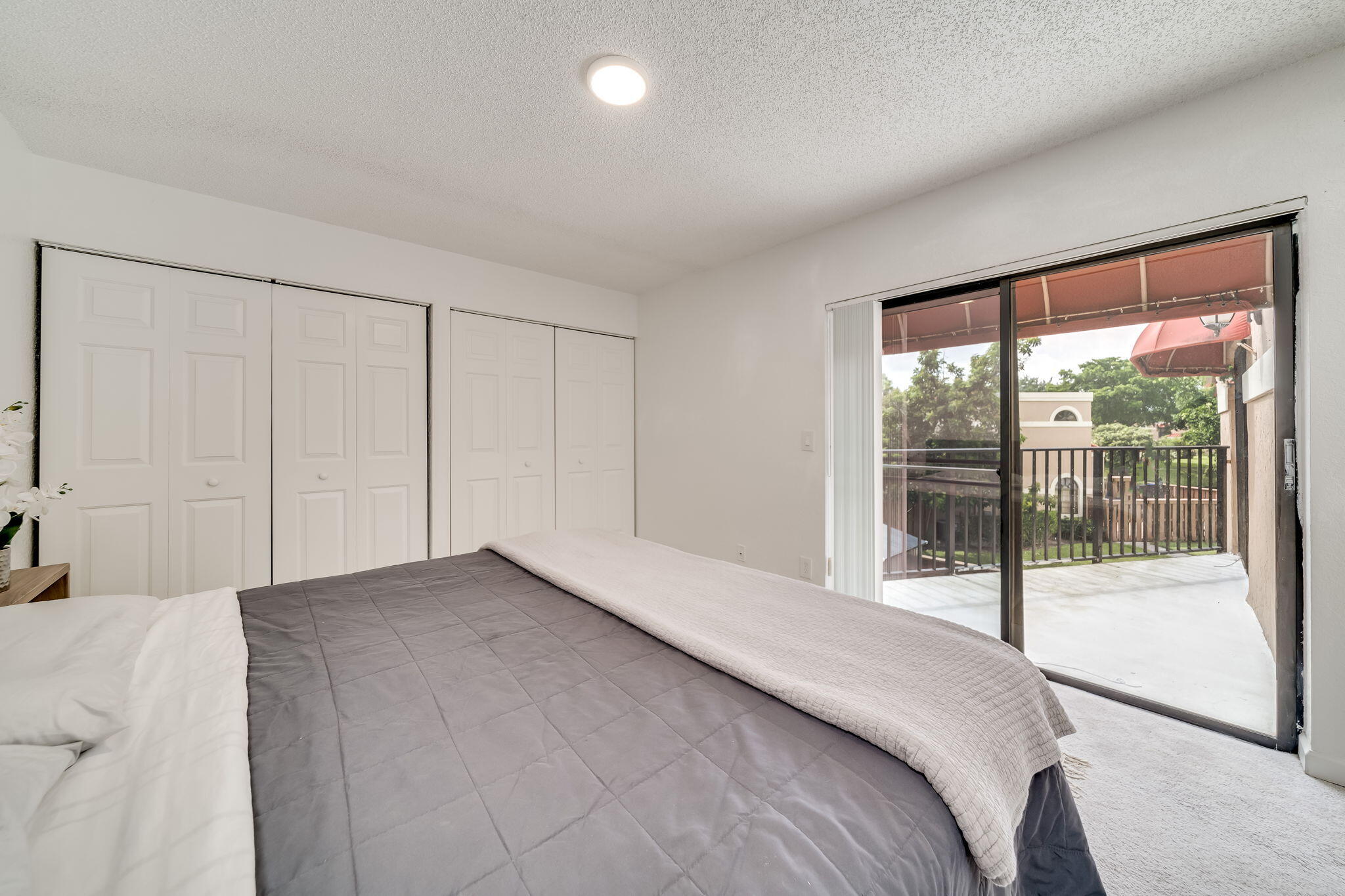 8116 Severn Drive, Unit C Boca Raton, FL 33433 - Photo 24 of 52 a bedroom with a large bed and a large window