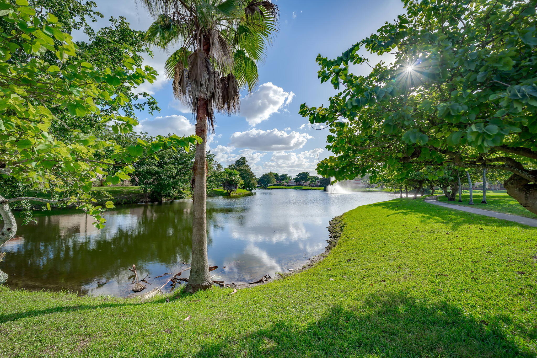 8116 Severn Drive, Unit C Boca Raton, FL 33433 - Photo 36 of 52 a backyard of a house with lots of green space and lake view