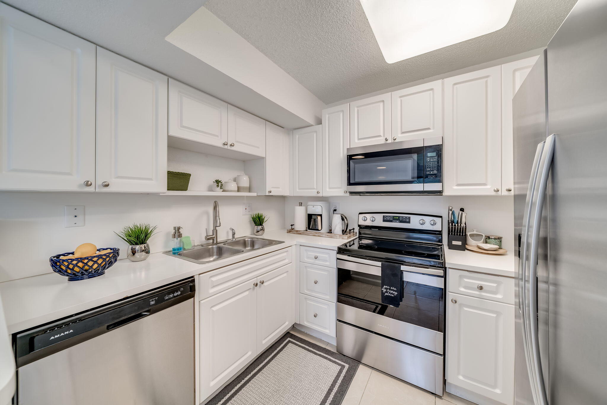 8116 Severn Drive, Unit C Boca Raton, FL 33433 - Photo 5 of 52 a kitchen with cabinets stainless steel appliances and a counter space