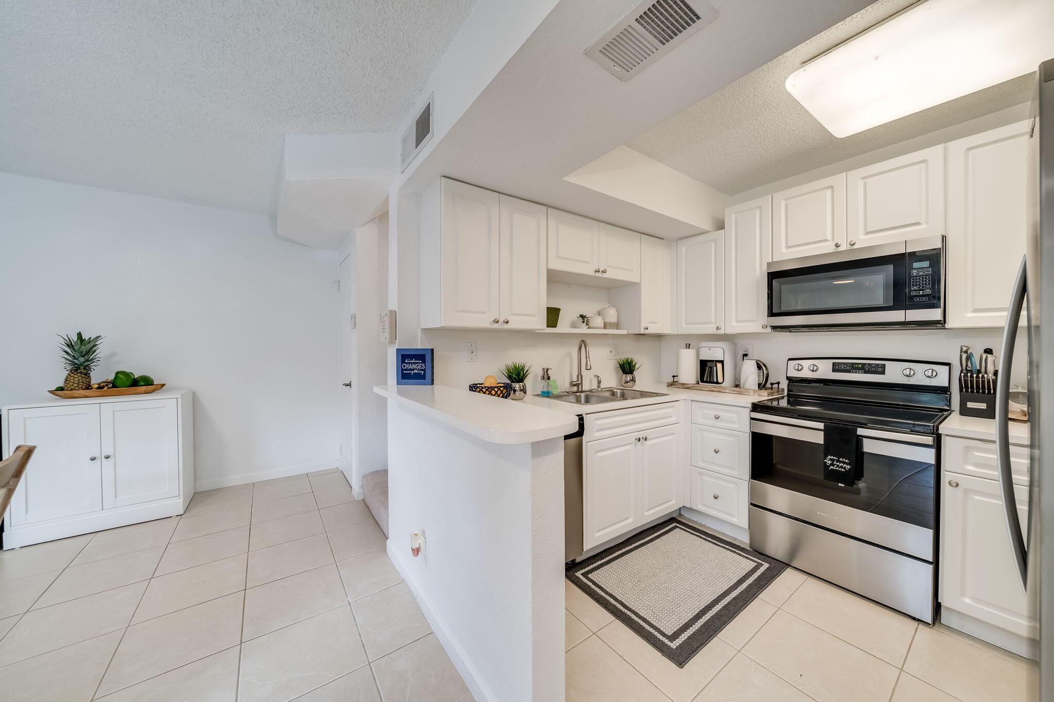 8116 Severn Drive, Unit C Boca Raton, FL 33433 - Photo 6 of 52 a kitchen with stainless steel appliances a stove microwave and cabinets