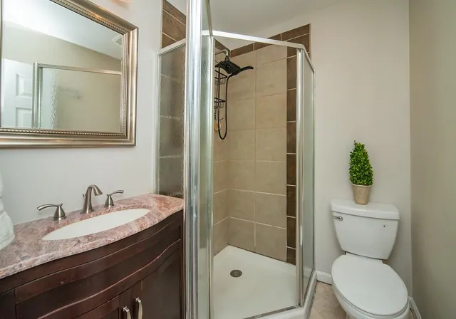 a bathroom with a granite countertop sink toilet and shower