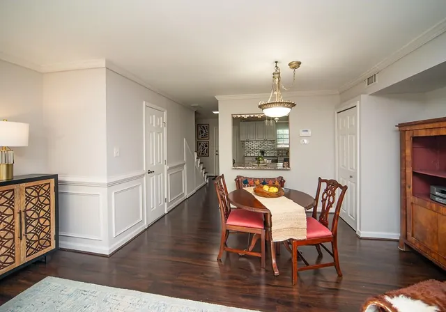 a dining room with furniture a chandelier and wooden floor