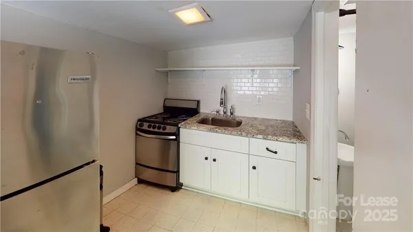 a kitchen with granite countertop white cabinets and white appliances