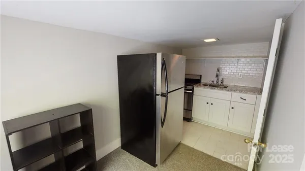 a kitchen with a refrigerator and a stove top oven