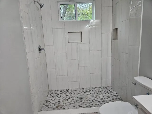 a bathroom with a toilet and a shower