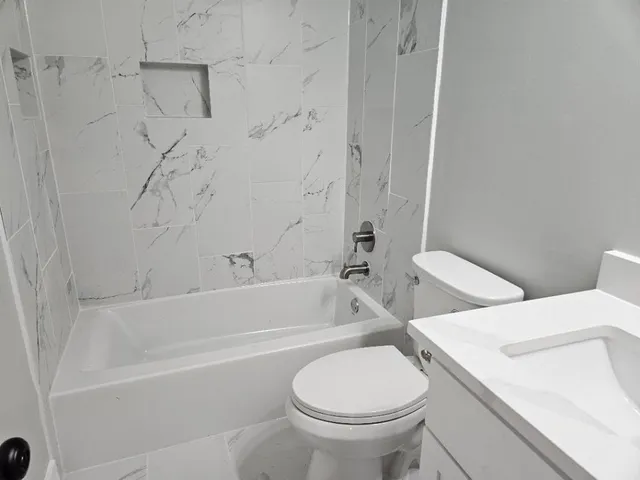 a bathroom with a toilet and a bath tub