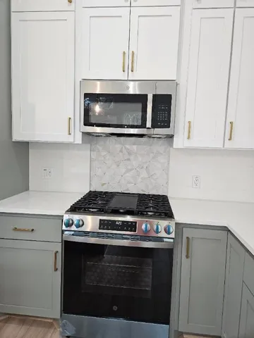 a stove top oven sitting inside of a kitchen
