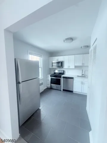 a kitchen with stainless steel appliances a refrigerator sink and cabinets