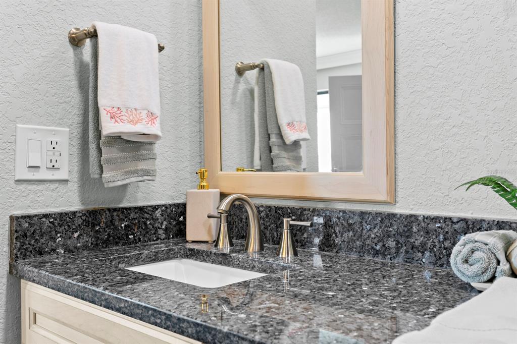 16332 Gulf Boulevard, Unit 3B Redington Beach, FL 33708 - Photo 15 of 91 a bathroom with a granite countertop sink and a mirror
