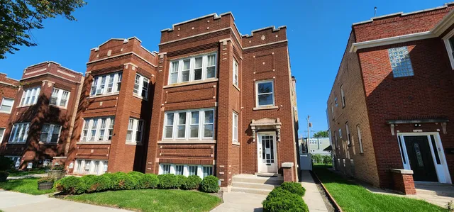 a view of a brick building next to a yard