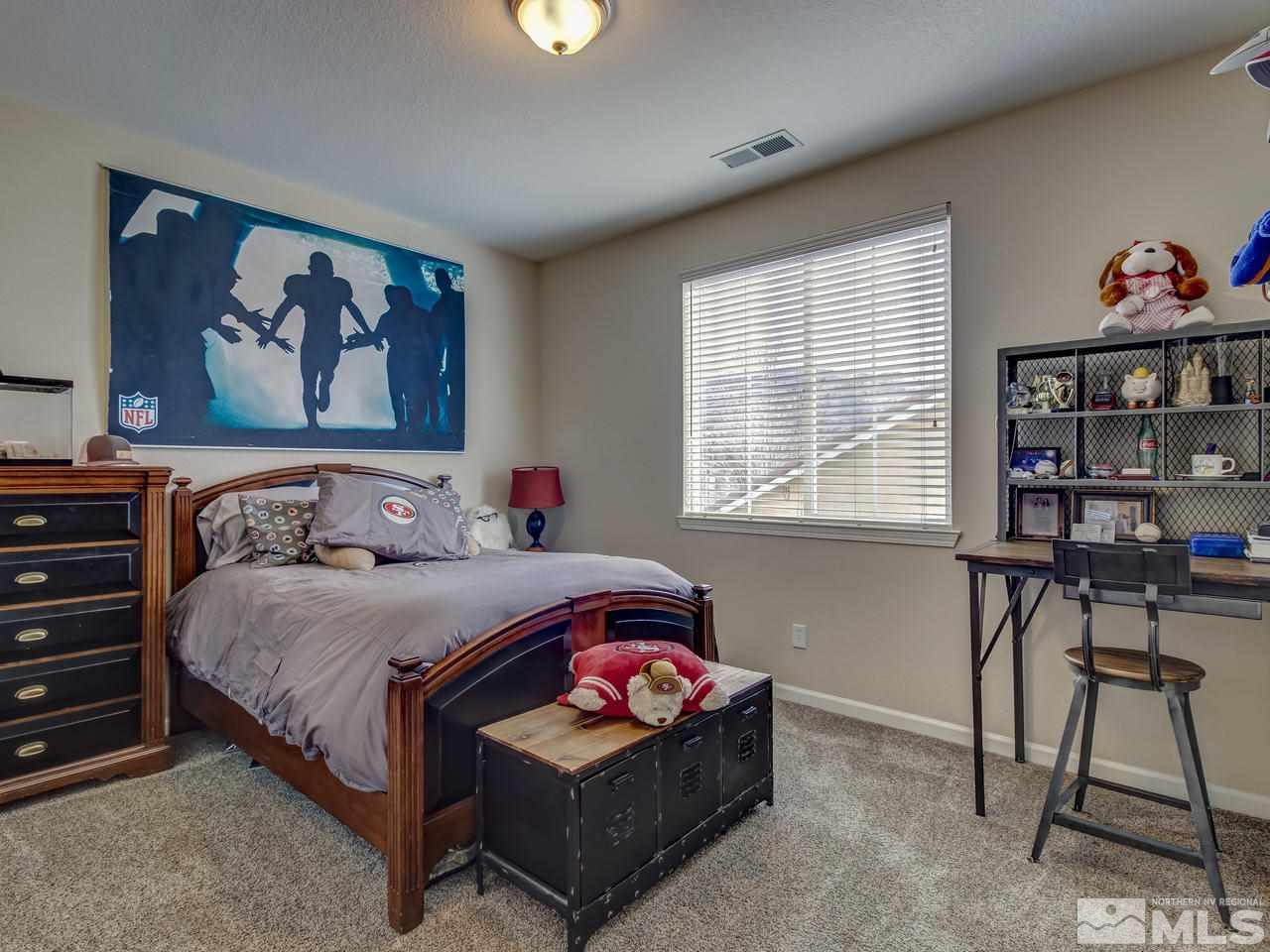 555 Little Sorrel Court Reno, NV 89521 - Photo 18 of 25 a bedroom with a bed a bookshelf and a window