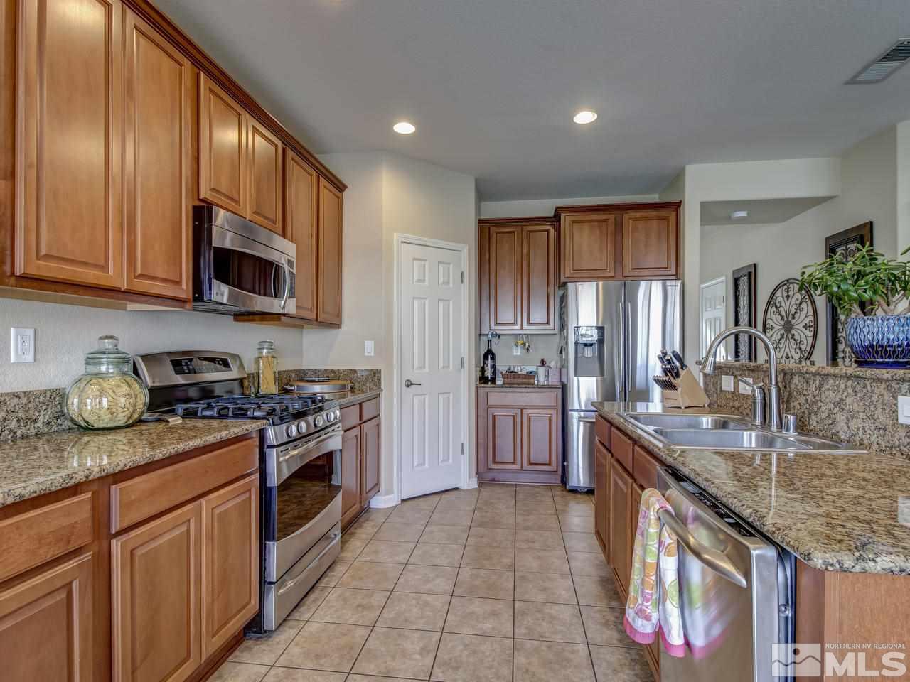555 Little Sorrel Court Reno, NV 89521 - Photo 3 of 25 a kitchen with stainless steel appliances granite countertop a stove a sink and a microwave