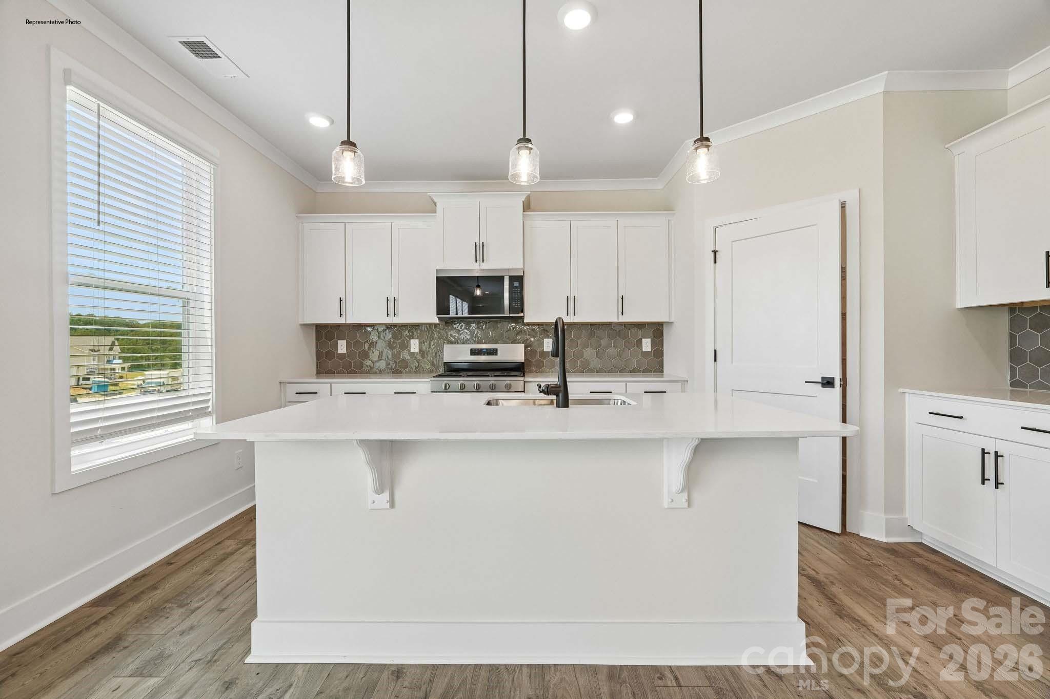541 Mahogany Road York, SC 29745 - Photo 11 of 32 a kitchen with kitchen island white cabinets and refrigerator