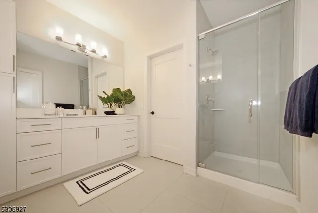 a spacious bathroom with a shower sink and mirror