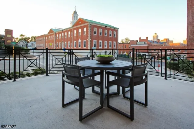 a view of a roof deck with table and chairs a barbeque