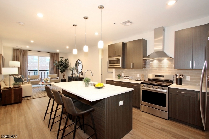 30 Court Street, Unit 58 Morristown, NJ 07960 - Photo 7 of 28 a kitchen with stainless steel appliances granite countertop a stove a sink dishwasher and a refrigerator with wooden floor