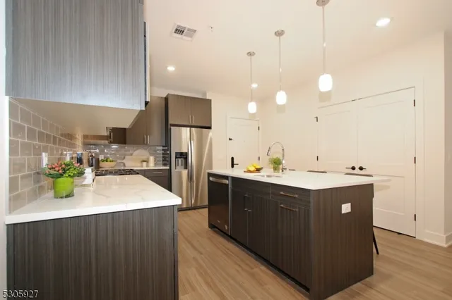 a kitchen with a sink a counter top space appliances and cabinets