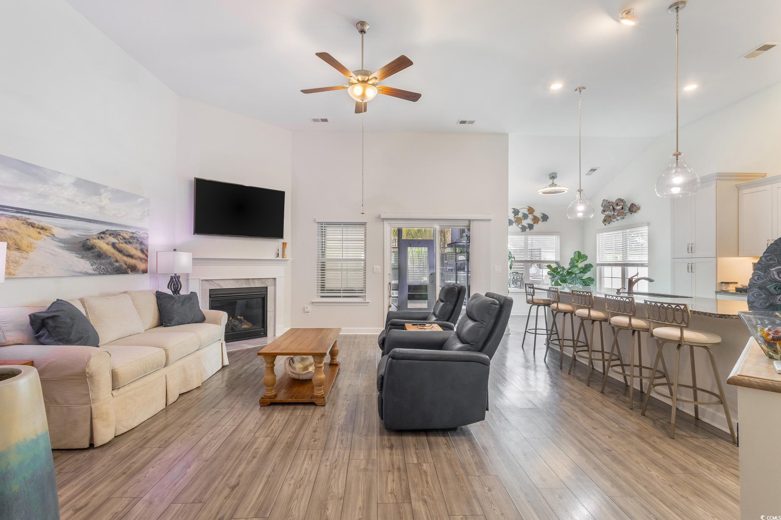 540 Canborough Lane Murrells Inlet, SC 29576 - Photo 14 of 40 Living area with a towering ceiling, light wood-style flooring, a glass covered fireplace, ceiling fan, and recessed lighting