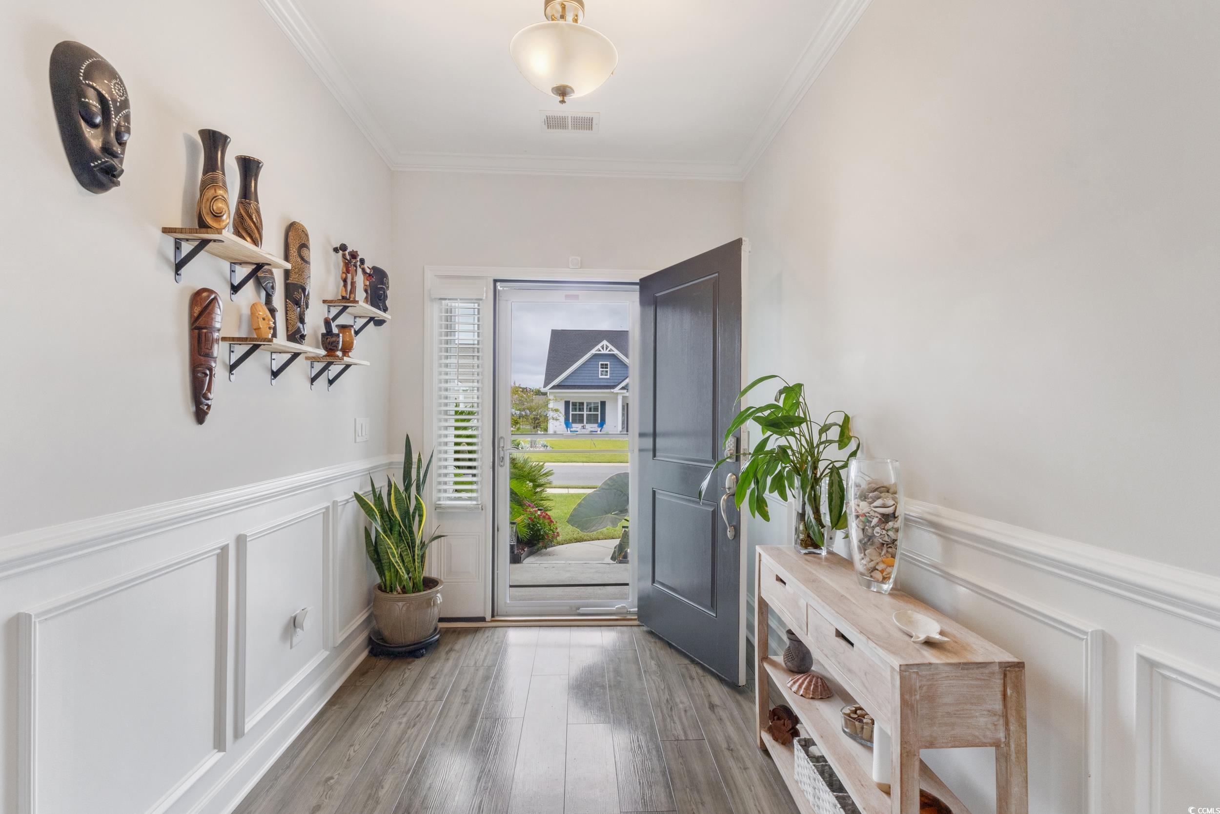 540 Canborough Lane Murrells Inlet, SC 29576 - Photo 17 of 40 Doorway featuring a decorative wall, a wainscoted wall, ornamental molding, and wood finished floors