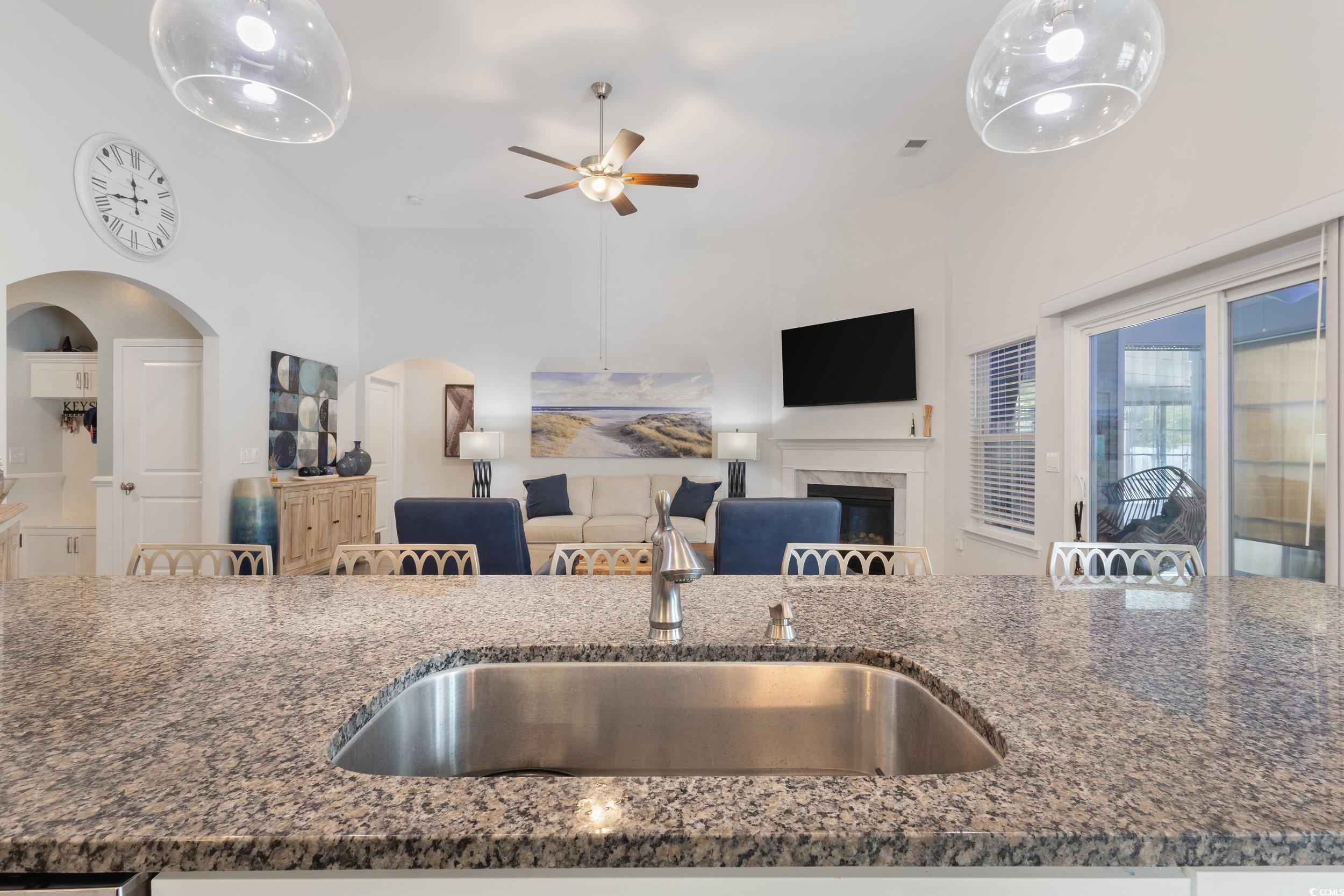 540 Canborough Lane Murrells Inlet, SC 29576 - Photo 40 of 40 Kitchen with dark stone countertops, a glass covered fireplace, a ceiling fan, and open floor plan