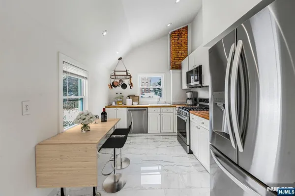 a kitchen with stainless steel appliances granite countertop a refrigerator and a stove top oven