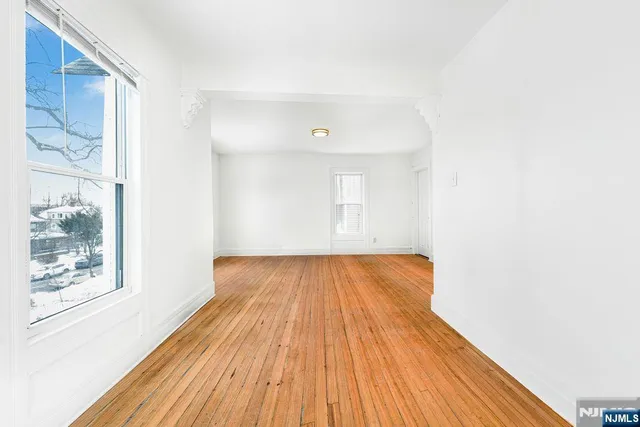 a view of a room with wooden floor and window