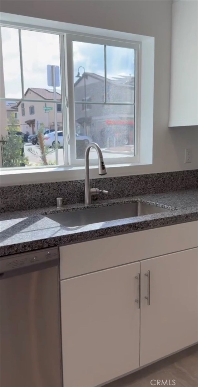 a bathroom with a sink and a large mirror next to a window