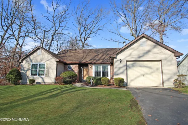 a front view of a house with a garden and trees