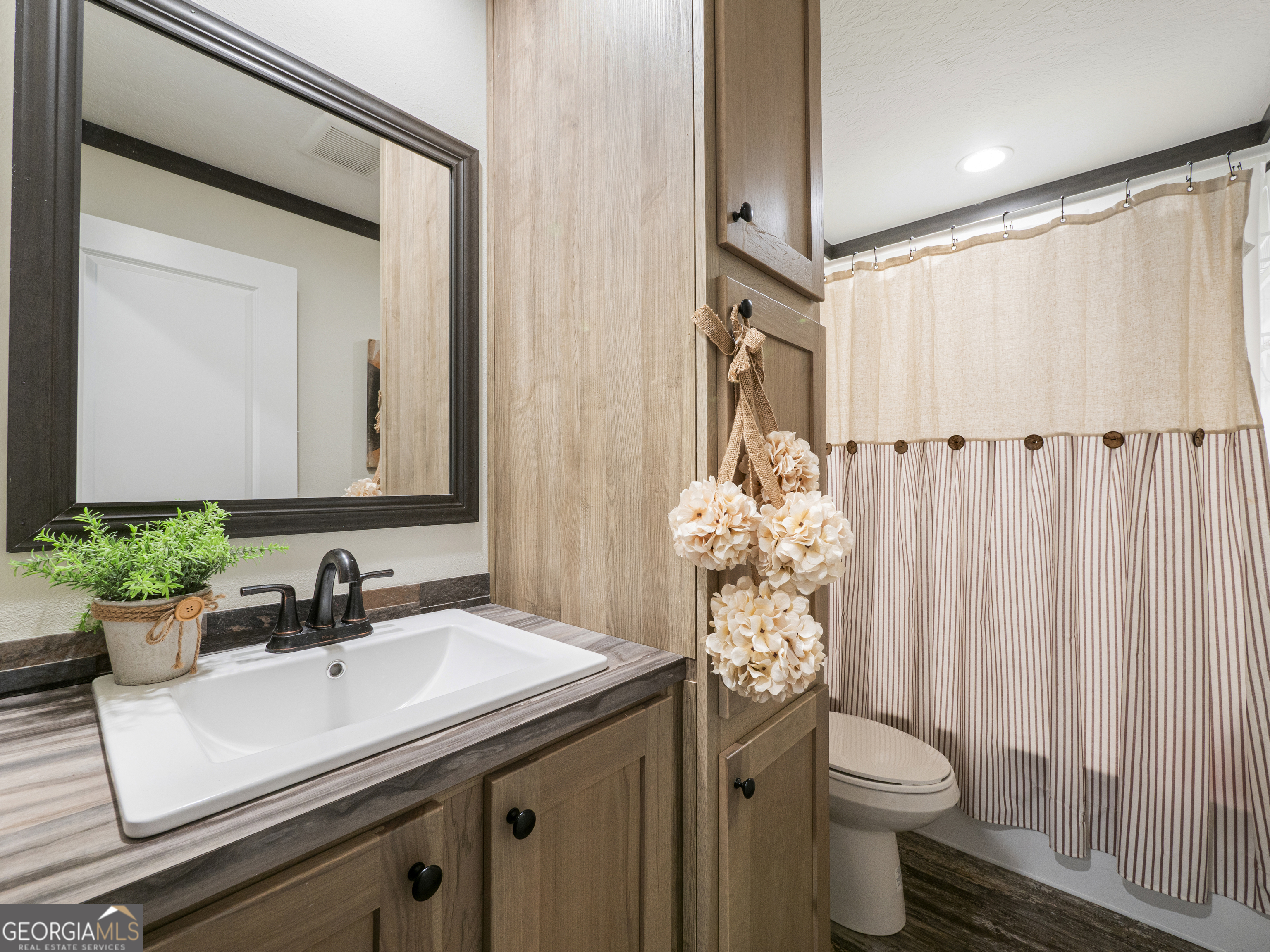 163 M M T Trail Commerce, GA 30530 - Photo 22 of 32 a bathroom with a sink a toilet and a mirror