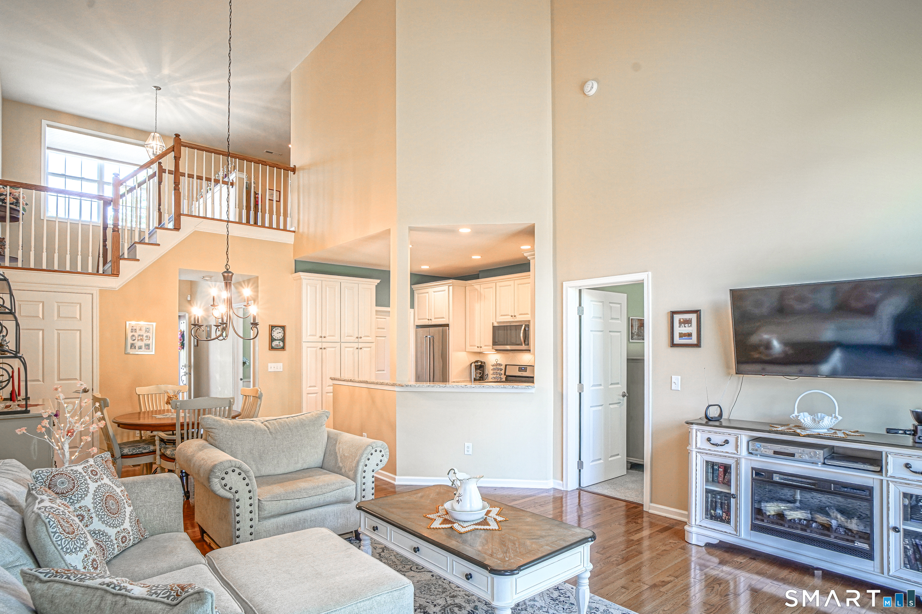 6 Lilac Lane, Unit 6 Prospect, CT 06712 - Photo 8 of 40 The living room flows to the kitchen, with a breakfast bar and high ceilings, overlooking the family room above.