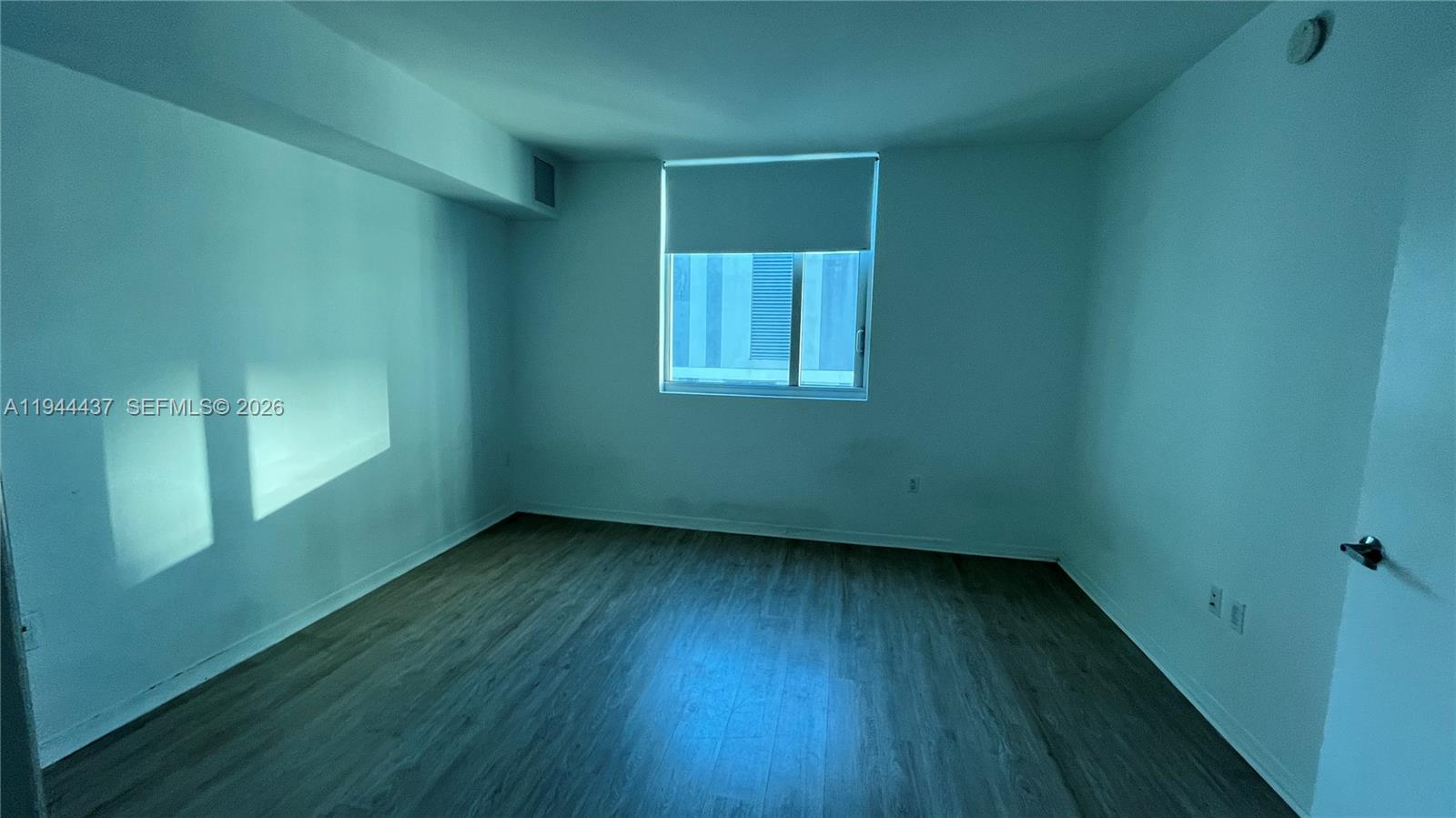 55 Southeast 6th Street, Unit 2601 Miami, FL 33131 - Photo 15 of 46 an empty room with wooden floor and windows