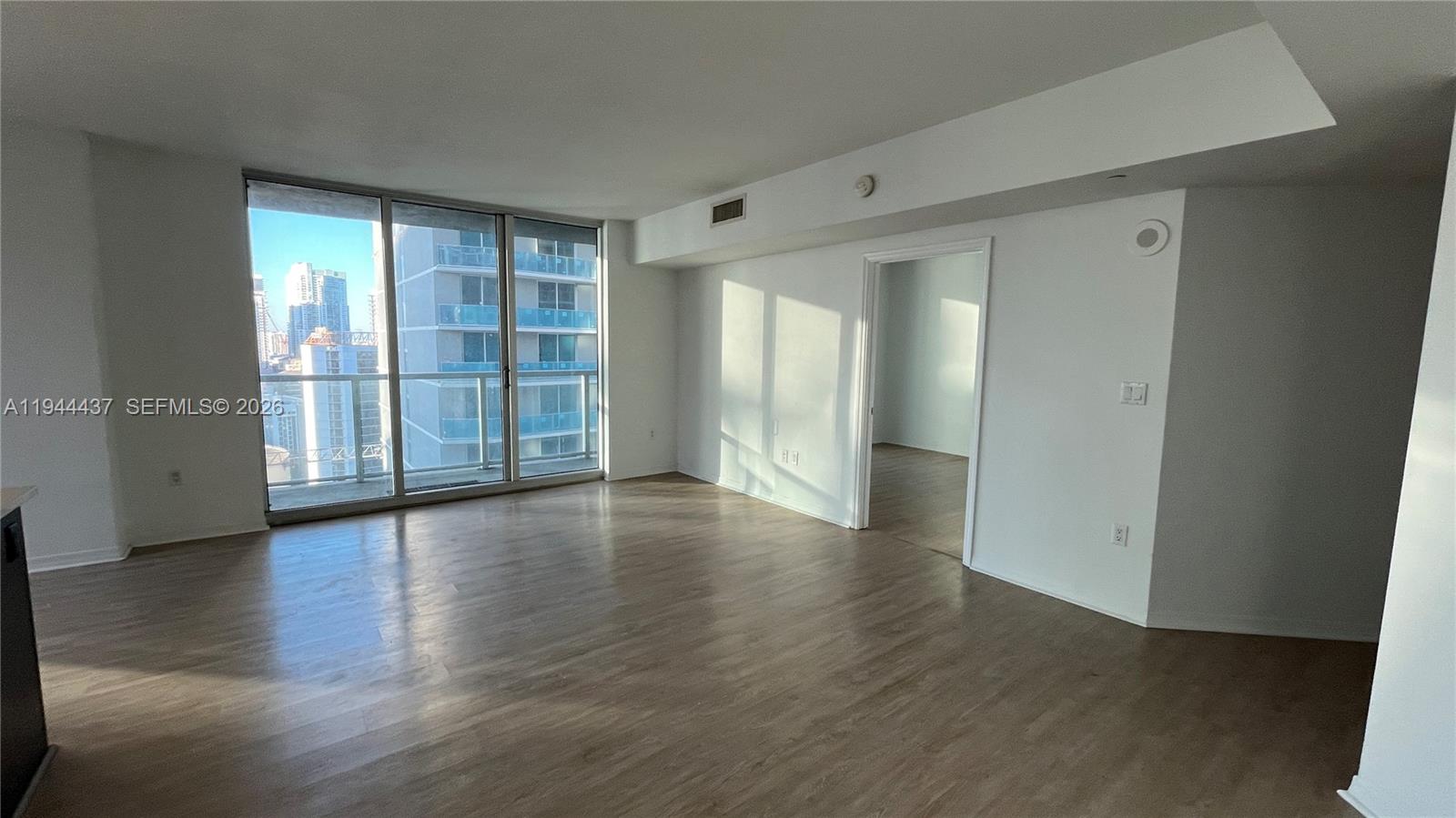55 Southeast 6th Street, Unit 2601 Miami, FL 33131 - Photo 2 of 46 wooden floor in an empty room with a window