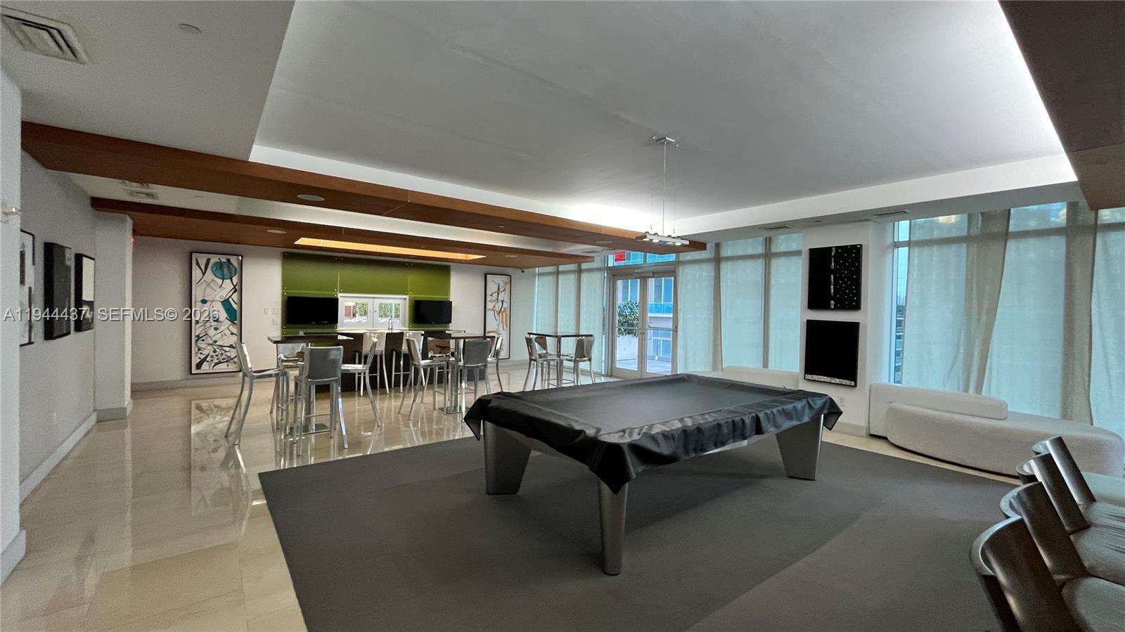 55 Southeast 6th Street, Unit 2601 Miami, FL 33131 - Photo 42 of 46 a living room with furniture pool table and a large window
