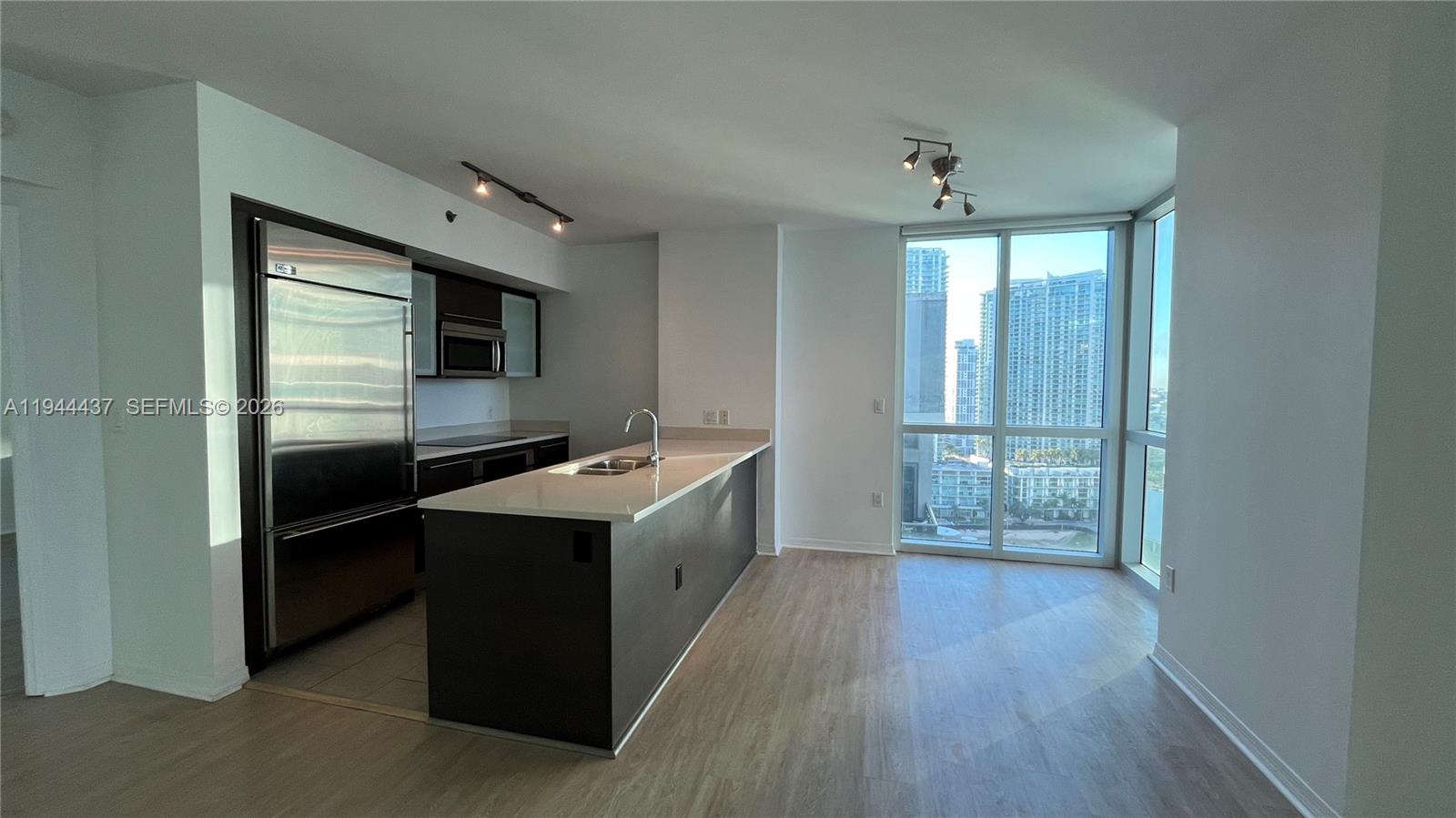 55 Southeast 6th Street, Unit 2601 Miami, FL 33131 - Photo 5 of 46 a kitchen with kitchen island granite countertop a sink appliances and cabinets