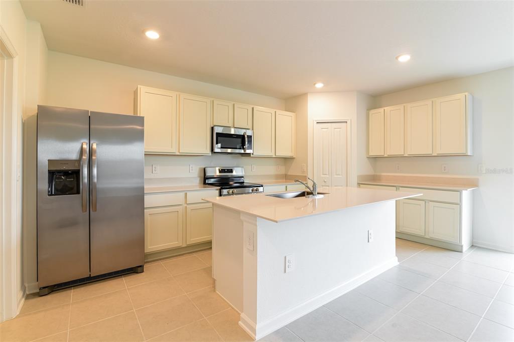 4009 Old Ml Road Haines City, FL 33844 - Photo 22 of 24 a kitchen with kitchen island a refrigerator sink and cabinets