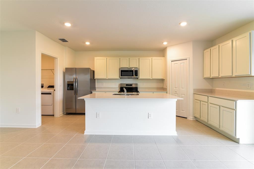 4009 Old Ml Road Haines City, FL 33844 - Photo 4 of 24 a large kitchen with stainless steel appliances granite countertop a stove a refrigerator a sink a microwave and island