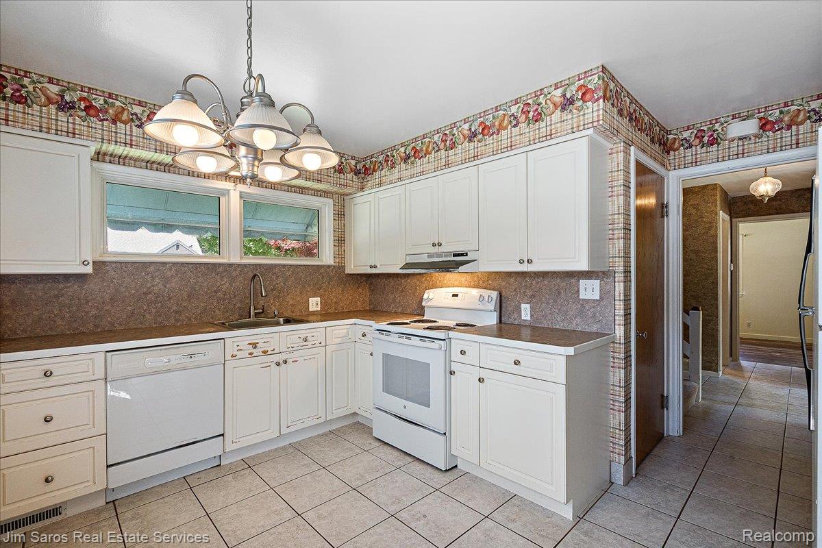 1010 Nottingham Road Grosse Pointe, MI 48230 - Photo 8 of 30 Kitchen featuring white cabinetry, a white dishwasher, a white range, a stainless steel sink, and light-toned tile flooring