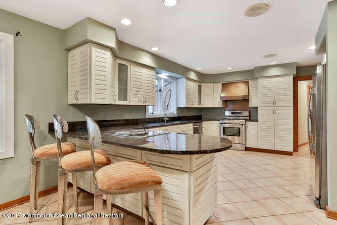 1644 Martin Road Neptune, NJ 07753 - Photo 22 of 42 a kitchen with stainless steel appliances granite countertop a stove a sink a refrigerator white cabinets and chairs